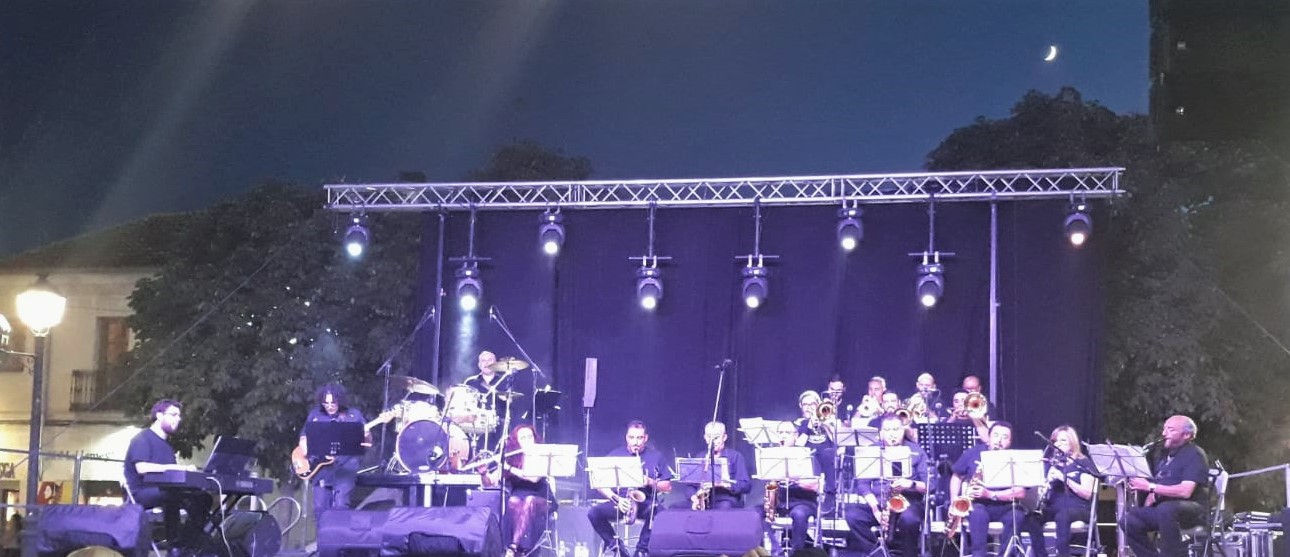 Una foto de la Big Band en un concierto al aire libre por la noche
